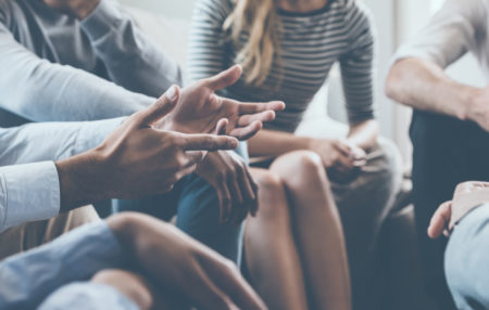 group of 5 people sitting together talking