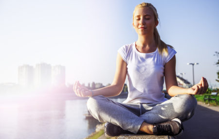 woman meditating on a ledge