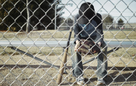 child sitting on the bench during a baseball game