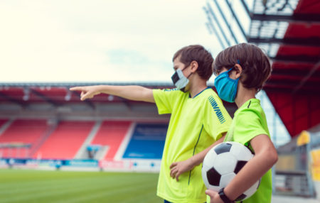 two youth soccer players pointing at the field and talking