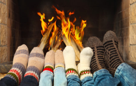 people warming their feet by a fire