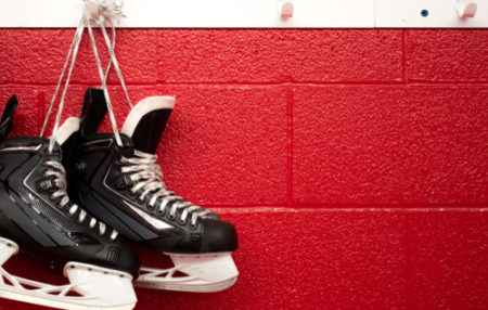 photo of hockey skates hung on a wall