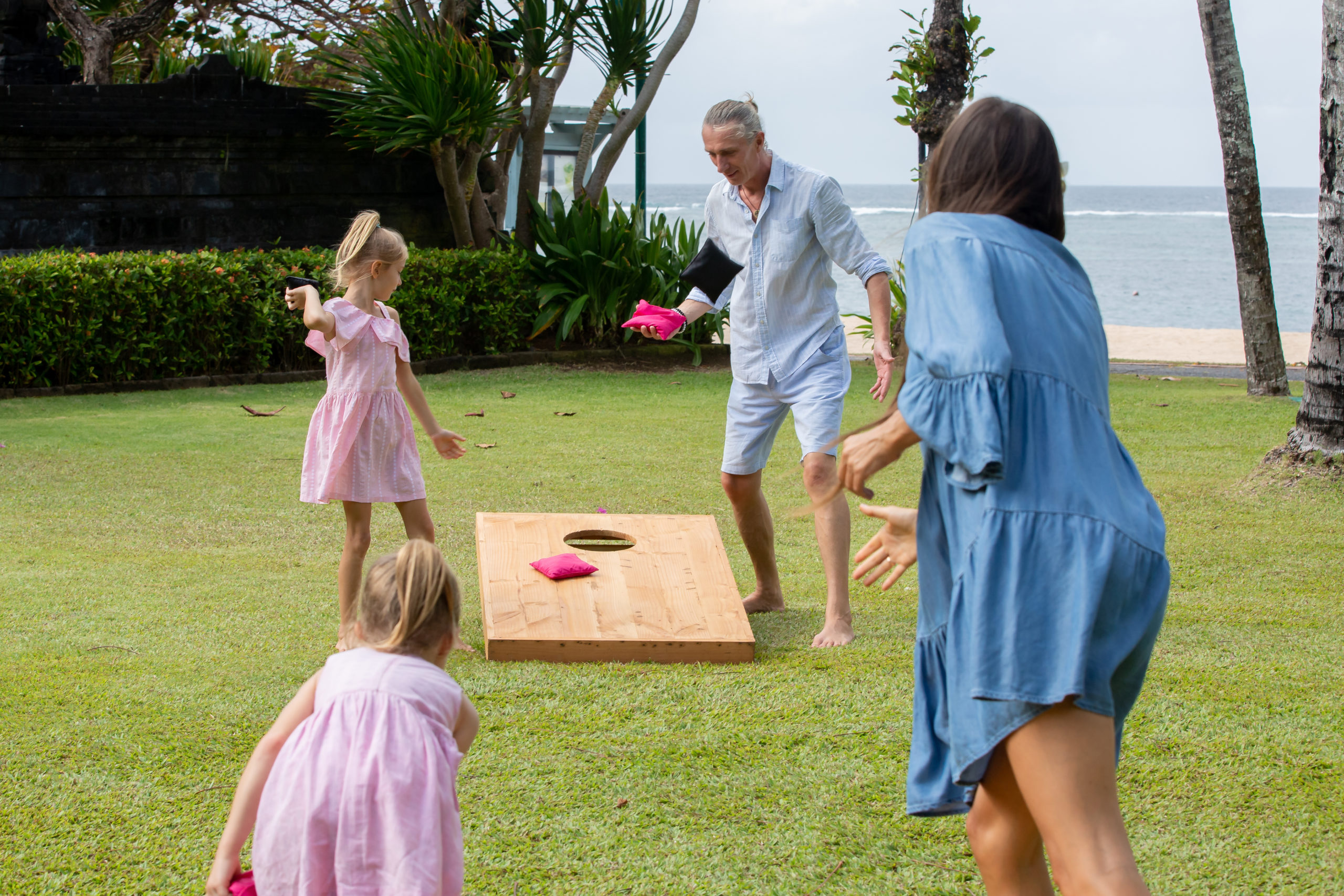 photo of a family playing cornhole