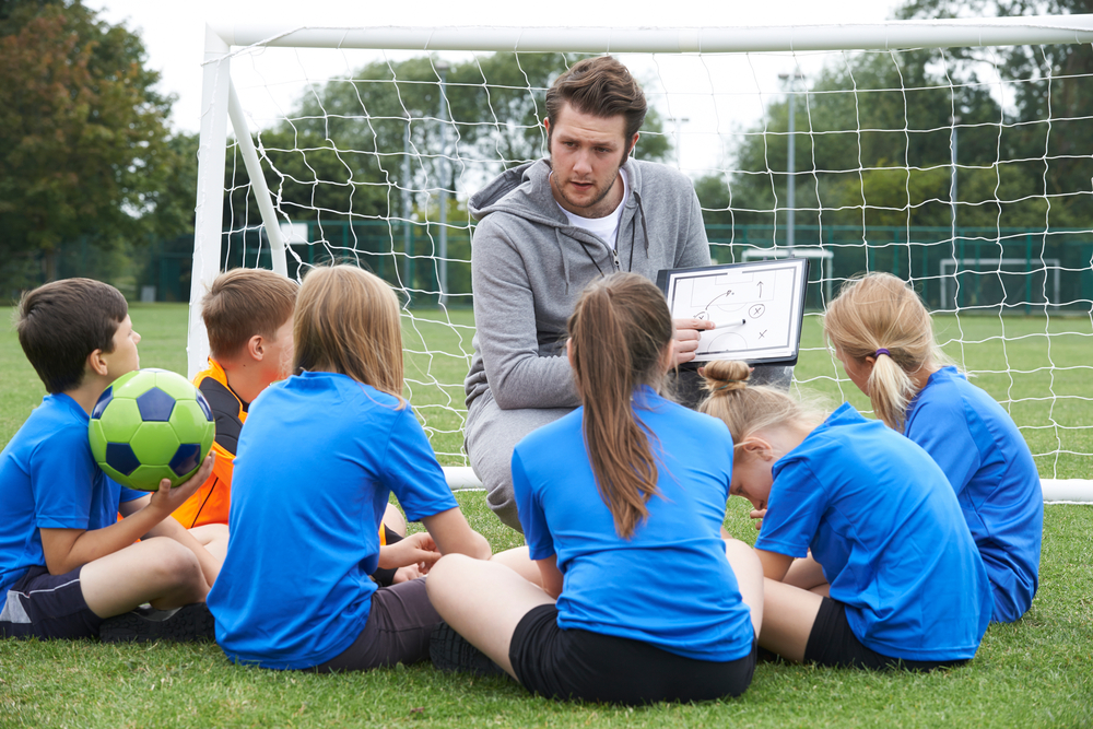 coach presenting a game plan to his soccer team