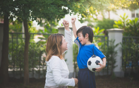 mom and son cheering while playing soccer