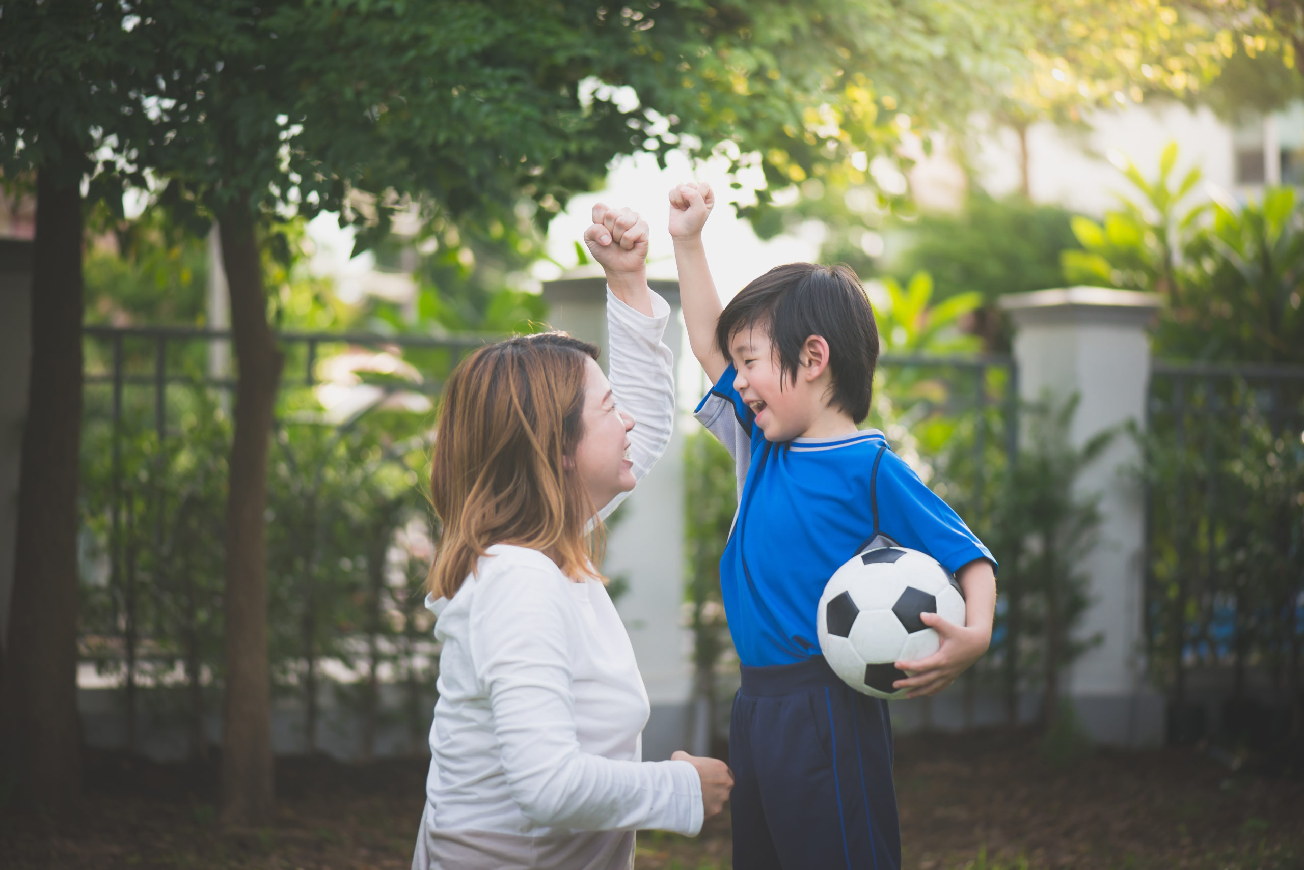 mom and son cheering while playing soccer